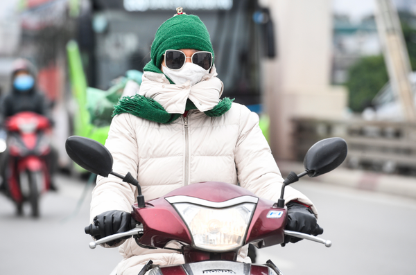 하노이의 한 여성 오토바이 운전자가 강추위에 방한복으로 몸을 꽁꽁 싸맨 채 장갑까지 끼고 운전을 하고 있다. / 사진=VN익스프레스